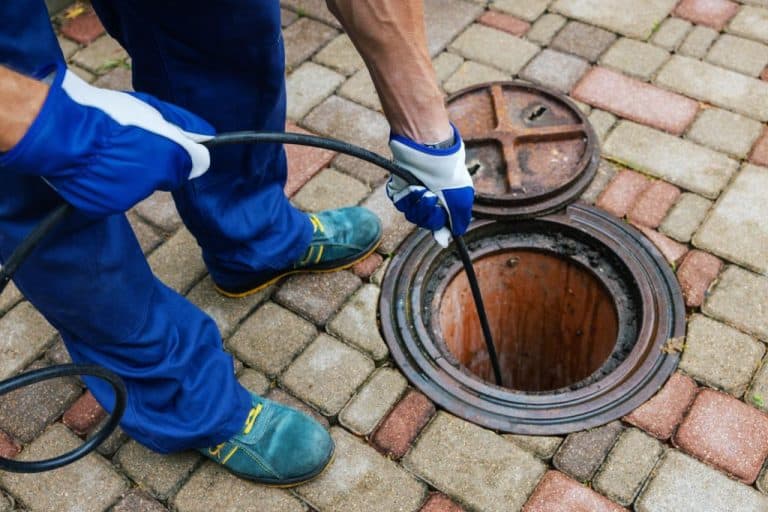 Curage mécanique d'une canalisation avec un furet de plomberie